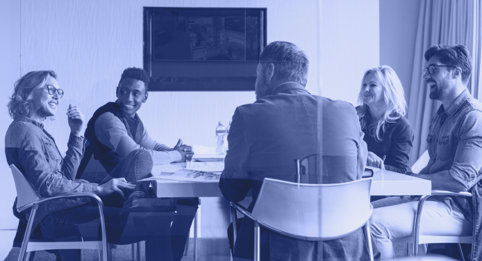 A diverse group of business professionals sitting around a board room table